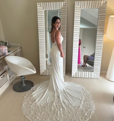 a woman in a wedding dress standing in front of a mirror