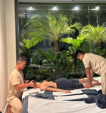 two men massaging a women in massage room