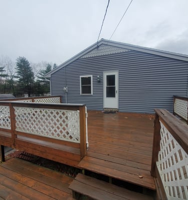 a house with a deck and a white truck parked in front of it