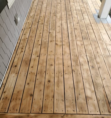 a wooden deck with a bench and a yellow umbrella