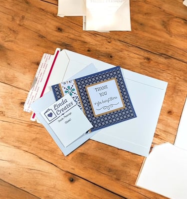 Thank You card, envelope and mailer on a table ready to be shipped.