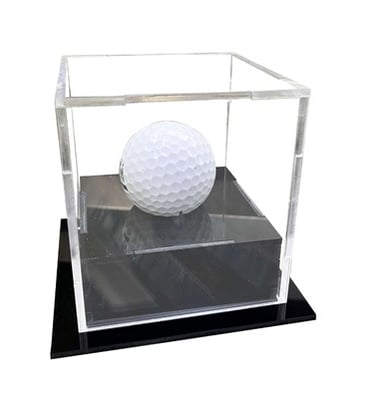 Small acrylic display box with a golf ball inside on a black base.