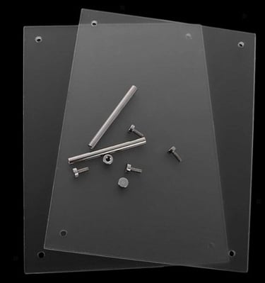 Two clear acrylic sheets and metal standoff parts arranged on a black surface.