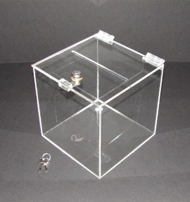Acrylic suggestion box with a key lock and keys beside it.