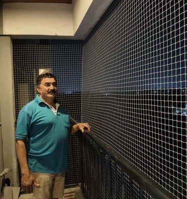 Completed balcony net protecting plants and pets on a cozy Bangalore balcony.