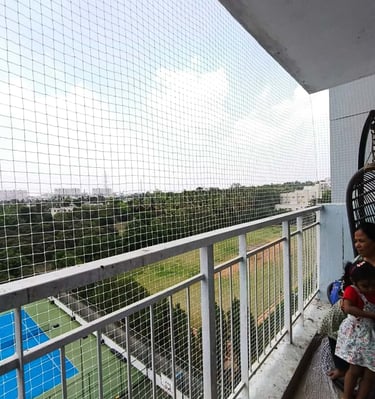 Wide shot of a colorful safety net protecting a play area in a Koramangala apartment.
