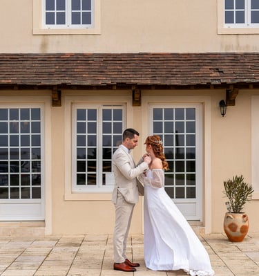 a bride and groom standing in front of a house