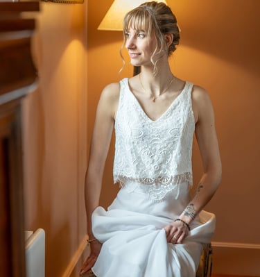 a woman in a white dress sitting on a chair