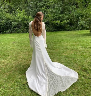 a woman in a white dress standing in the grass