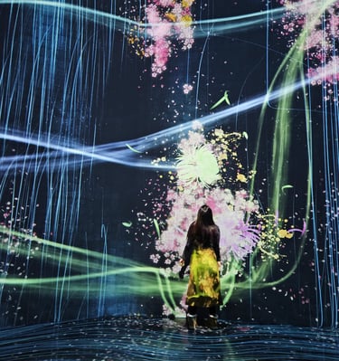 a woman in a yellow dress standing in front of a large screen with a painting