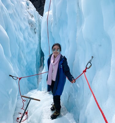 a woman in a blue jacket and pink scarf on a rope tied to a rope