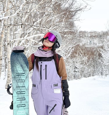 a snowboarder in a purple snowsuit and a snowboard
