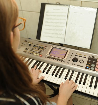 aluna estudando partitura com metodo da escola toque talento
