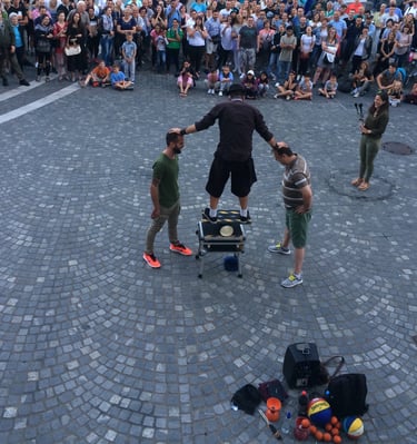 a man performing a street show balancing on a rola bola