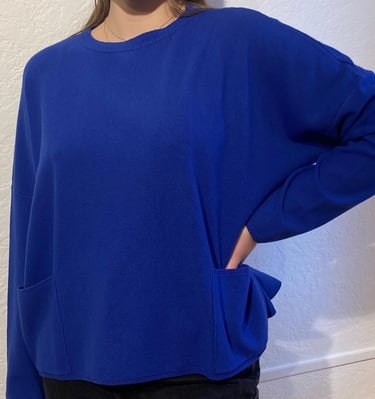 Une femme qui porte un pull bleu