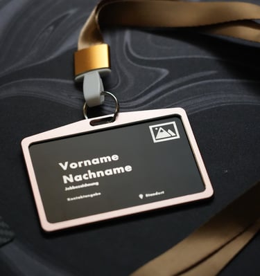A personalized black plastic ID card holder with a gold lanyard on a dark marble surface.