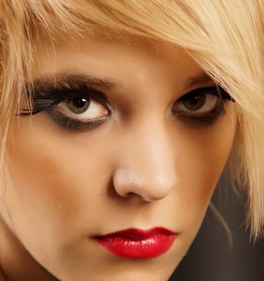 a beautiful woman with blonde hair, red lipstick and smokey eye makeup
