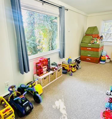 an organized playroom with a window and toys