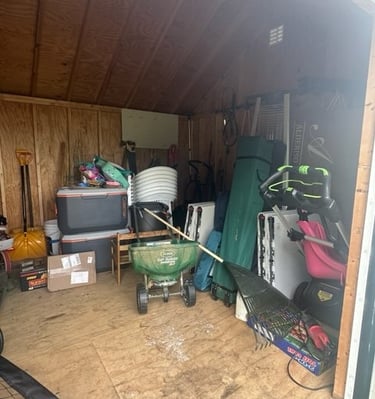 a cluttered shed with outdoor equipment