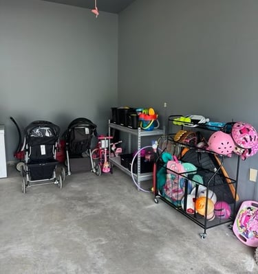 an organized garage space with sports equipment and strollers