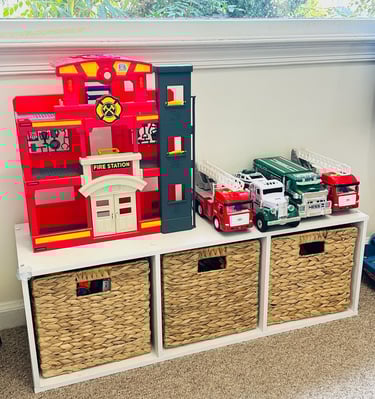 an organized shelving unit with bins and toys