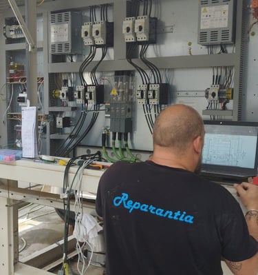 Técnico programando controlador de sistemas de central frigorífica.