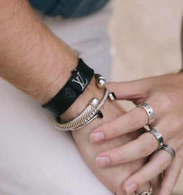 a man and woman holding hands with bracelets