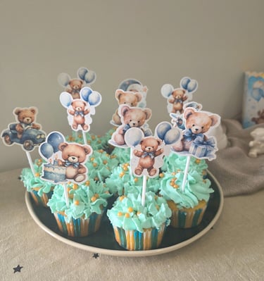 Blue teddy bear cupcakes with themed toppers for a boy baby shower or birthday party.