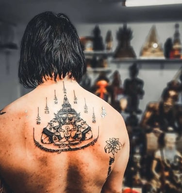 a man with a thai tattoo on his back and a tattoo on his back and traditional thai sak yant tattoo