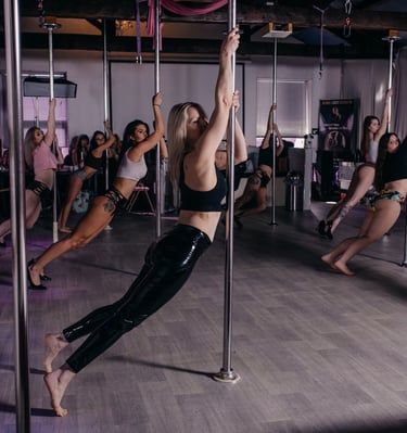 Image of Sxefit pole dancing class with all students leaning in the same pose