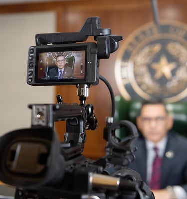 Texas Workforce Commissioner Julian Alvarez being recorded with a professional video camera.