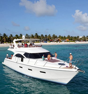 A sleek catamaran sailing near Isla Mujeres under a bright blue sky.