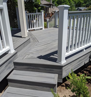 a deck with composite decking and white railings