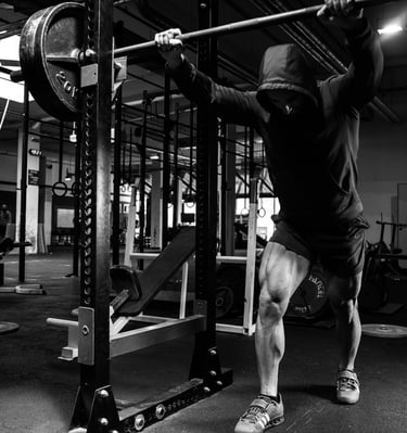 a man doing a pull up barbell in a gym