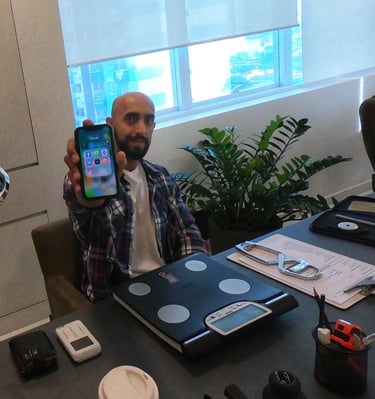 a man sitting at a desk with a cell phone in his hand
