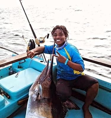 a man holding a fish on a boat
