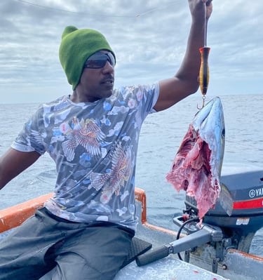 a man in a green hat and a fish on a boat