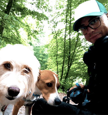 Foto von einem Mann mit zwei Hunden im Wald
