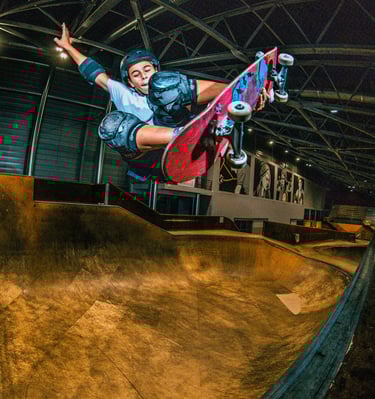 a man in a blue shirt is doing a trick on a skateboard pomge Marseille France skatepark