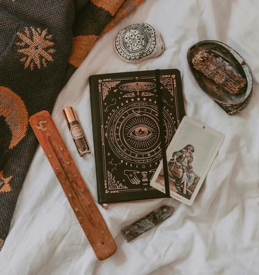 Tarot journal, sage, and crystals arranged for ritual work — tools used by Amber, Queen of Wands.