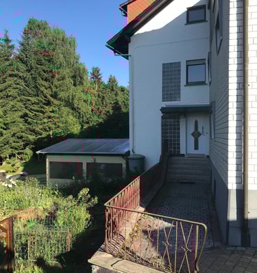 Separater Eingangsbereich des Neubaus mit angrenzendem Wintergarten links