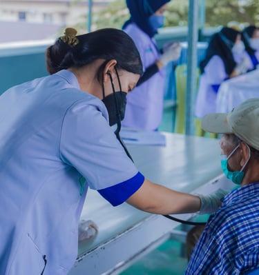Perawat memeriksa tekanan darah pasien lanjut usia di layanan kesehatan luar ruangan