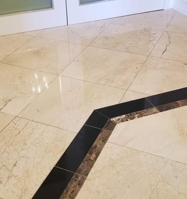 a bathroom with a marble floor and a glass door