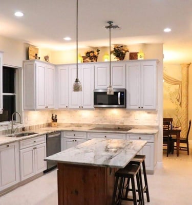 a kitchen with a large island and a table with chairs