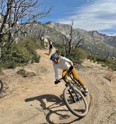 a man riding a bike on a dirt road