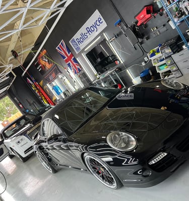luxury car detailers on a prosche and rolls royce