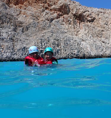 two people in life jackets in the water