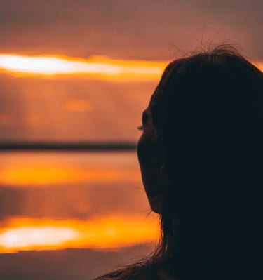 Mujer disfrutando el atardecer en Bacalar