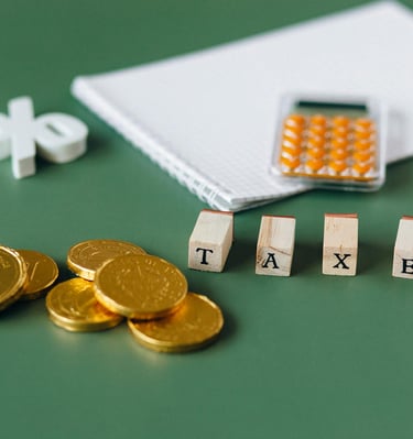 gold coins, calculator and word taxes show gold ira taxes and learning potential tax benefits