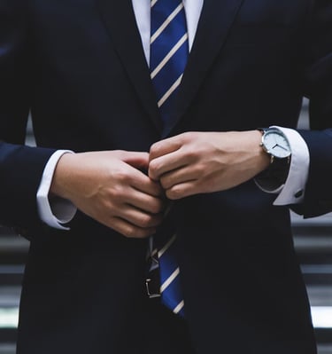 gold ira company worker with suit on in front of stairs representing choosing the right gold ira company